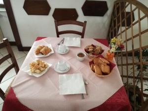uma mesa com uma toalha de mesa rosa com comida em Albergo al Castello em Millesimo