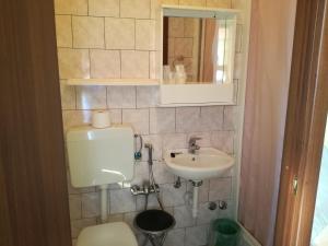 La salle de bains est pourvue de toilettes, d'un lavabo et d'un miroir. dans l'établissement Albergo al Castello, à Millesimo