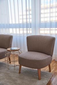 a living room with two chairs and a table at Luxury Apartment in the most privileged Lisbon in Lisbon