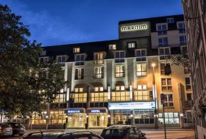 un edificio de apartamentos con coches estacionados frente a él en Maritim Hotel Würzburg, en Würzburg