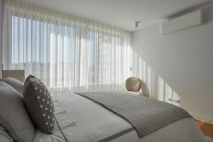 リスボンにあるLuxury Apartment in the most privileged Lisbonのベッドと大きな窓のある寝室