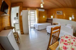1 Schlafzimmer mit 2 Betten, einem Tisch und Stühlen in der Unterkunft Pousada Gramadense in Gramado