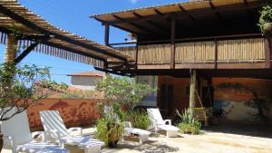 a group of white chairs sitting under a pergola at Hotel Pousada Latitude in Canoa Quebrada