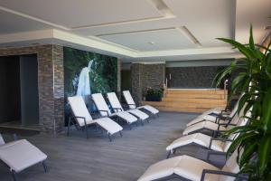 a waiting room with white chairs and a large screen at Hotel Terme Paradiso in Abano Terme