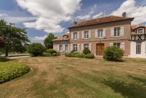 une grande maison en briques avec une grande cour dans l'établissement Chambre d'hotes de la Vallee, à Montaure