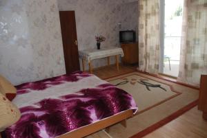 a bedroom with a purple bed and a table at " У Татьяны" in Cholpon-Ata