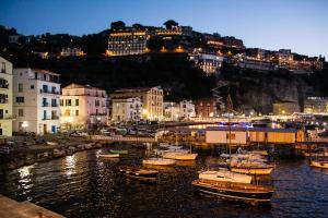 grupa łodzi zakotwiczona w porcie w nocy w obiekcie B&B Syrentum w Sorrento