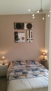 a bedroom with a bed with two lamps and pictures on the wall at Cottage sword beach in Hermanville-sur-Mer +24 photos