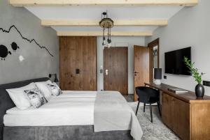 Dormitorio con cama, escritorio y TV en Biała Owca, en Zakopane