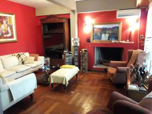 a living room with red walls and a fireplace at Chalet de las Tejas in Rosario