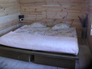 a bed in a room with a wooden wall at Pod Kotem in Rowy