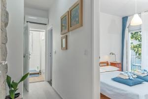 a white bedroom with a bed and a window at Beachfront Apartment Mala Tereza in Split