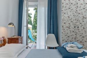 a bedroom with a bed and a chair and a window at Beachfront Apartment Mala Tereza in Split