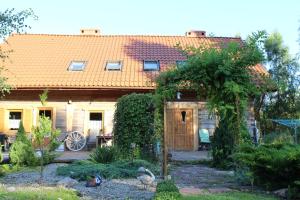 a house with a wooden door and a garden at Pod Kotem in Rowy
