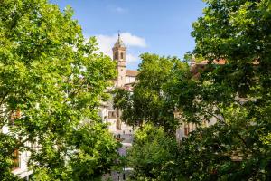 a building with a clock tower behind some trees at HABITAKA, Hogares de paso in Vitoria-Gasteiz