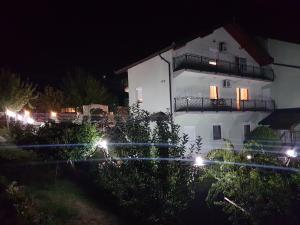 بيت الضيافة دينكا في سراييفو: مبنى أبيض مع أضواء أمامه في الليل