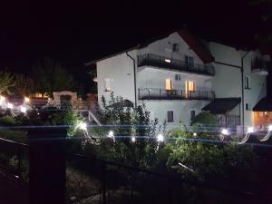 a white house with lights in front of it at night at Guest house Dinka in Sarajevo