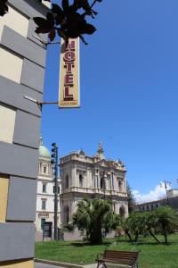 a building with a sign in front of it with a bench at Hotel Il Santuario - Pompei in Pompei