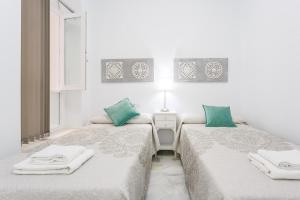カディスにあるCasa TANGUILLOS de Cadizの白い部屋のベッド2台 緑の枕付