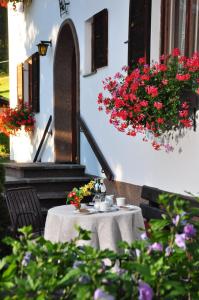 - une table avec des fleurs à côté d'un bâtiment dans l'établissement Haus Thurner, à Obsteig