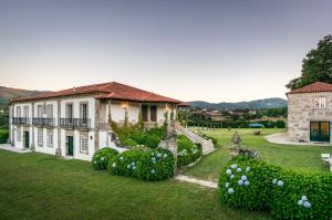a house with a large yard with bushes at Quinta de Luou in Santa Cruz do Lima