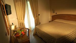 a bedroom with a bed and a bowl of fruit on a table at Hotel Portonuovo in Vieste