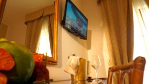 a dining room table with a television on the wall at Hotel Portonuovo in Vieste