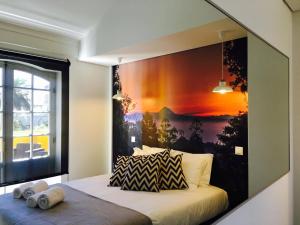 a bedroom with a large painting on the wall at Globo Happy Hostel in Angra do Heroísmo