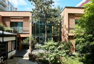 an external view of a building with trees and plants at Eden Lodge Paris in Paris