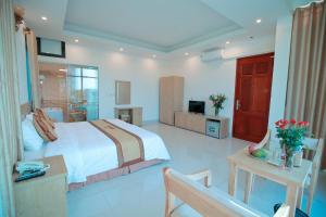 Anova Airport Hotel في Noi Bai: غرفة نوم بسرير وطاولة وتلفزيون