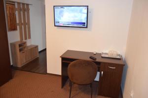 a room with a desk and a television on a wall at Casa Someseana in Gîlgău