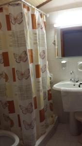 a bathroom with a shower curtain with butterflies on it at Kristi in Póros Kefalonias