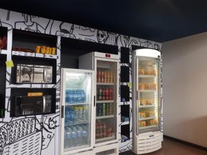 a room with two refrigerators with drinks in them at ibis budget Barbacena in Barbacena