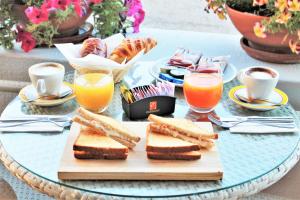 una mesa con sándwiches y dos vasos de zumo de naranja en AHR Costa Serena Village, en Palau