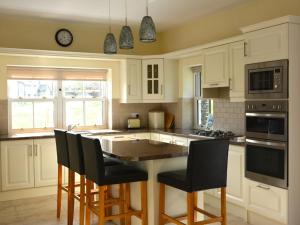 a kitchen with white cabinets and a table with chairs at Rivers Bend Cottage in Skull +1 photo