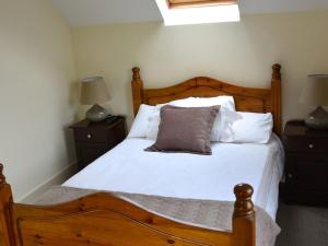 a bedroom with a wooden bed with a pillow on it at Rivers Bend Cottage in Skull