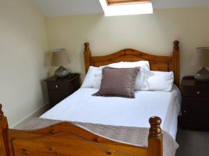 
a bed with a white bedspread and pillows at Rivers Bend Cottage in Skull
