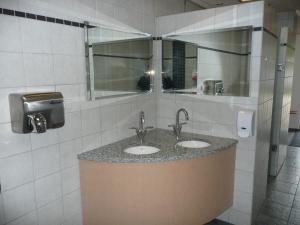 a bathroom with two sinks and a mirror at Gåsevig Strand Camping in Haderslev