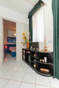 a living room with a desk and a window at Holiday ApartHotel in Santa Maria