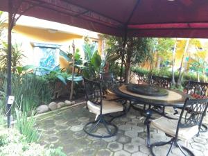 een patio met een tafel en stoelen onder een parasol bij Hotel Farah in Nuevo San Juan Parangaricutiro
