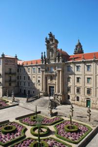 a large building with a courtyard with flowers at Pensión Acibeche in Santiago de Compostela