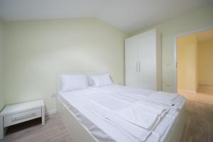 ティミショアラにあるGaga Residence 13の白いベッドルーム(白いシーツを使用した大型ベッド1台付)