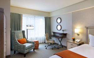 a hotel room with a bed and a desk and a chair at Seaport Hotel® Boston in Boston