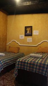 a room with two beds and a picture on the wall at Hotel Calle Ancha in Antigua Guatemala