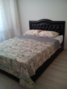 a bedroom with a bed with a floral bedspread at C.C HOME SUİT APART in Edirne