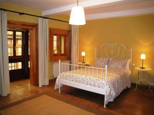 1 dormitorio con 1 cama blanca con dosel blanco en Casa Cotiellu, en Llanes