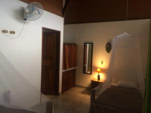 a room with a bedroom with a bed and a lamp at Hotel Suizo Loco Lodge & Resort in Cahuita