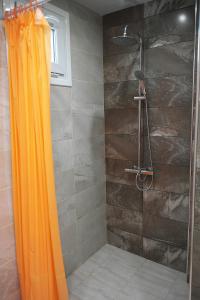 a shower with an orange shower curtain in a bathroom at Water House in Shumen