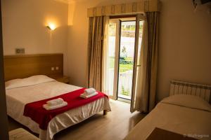 a bedroom with two beds and a sliding glass door at Hotel Pinheiro Manso in Seara