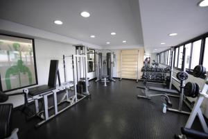 a gym with several treadmills and a tv and machines at Apart-Hotel in Goiânia